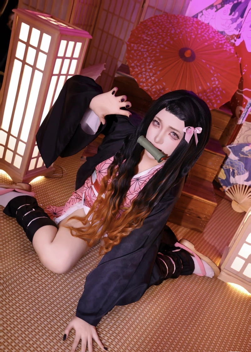 Ảnh cosplay Nezuko với ống tre ngậm trước miệng